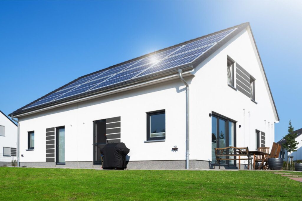 Weißes Haus mit Solaranlage auf dem Dach